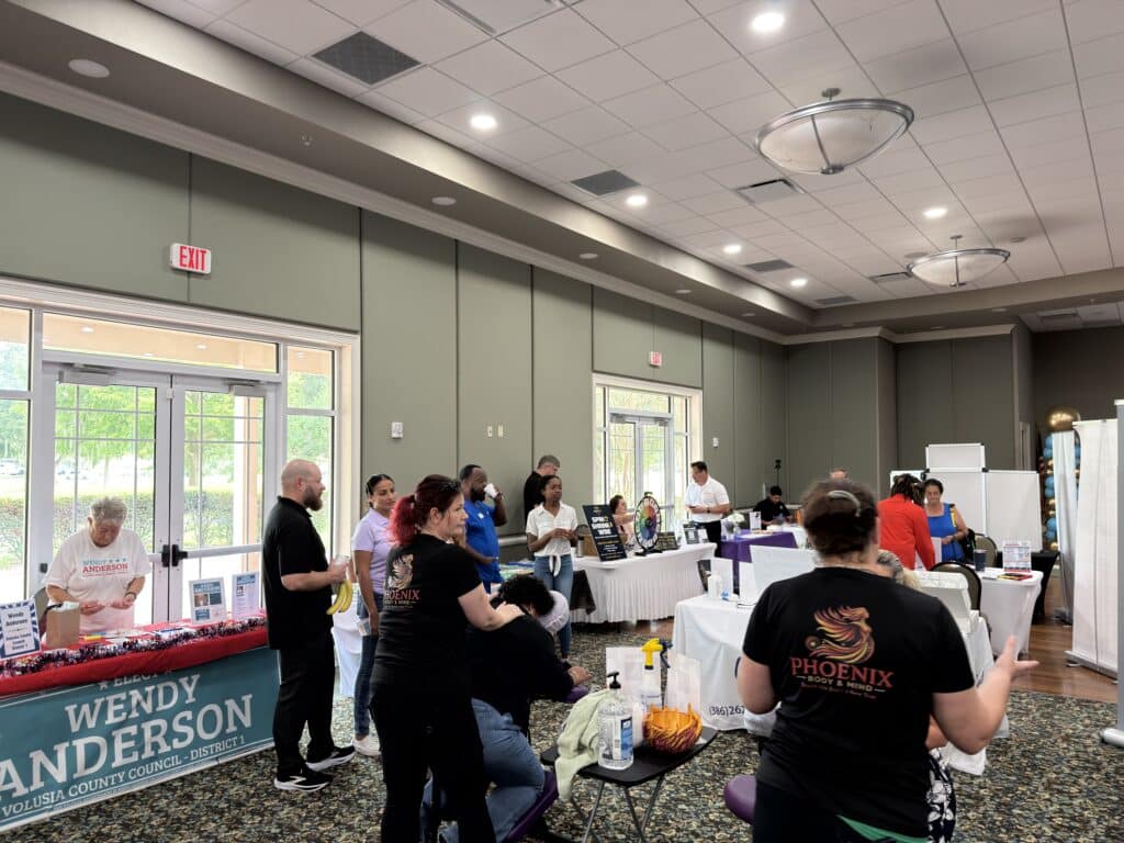 Event hall filled with vendor tables and guests