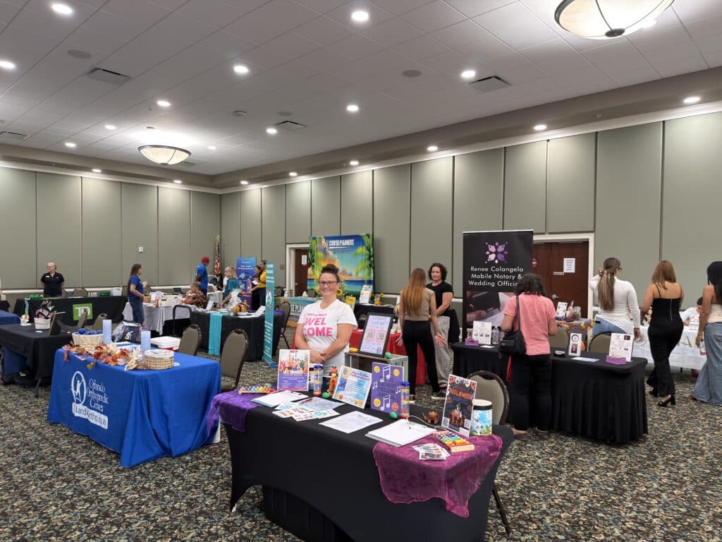 Wide view of vendor tables set up in the event hall