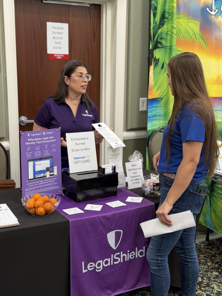 Two women talking at a LegalShield vendor table