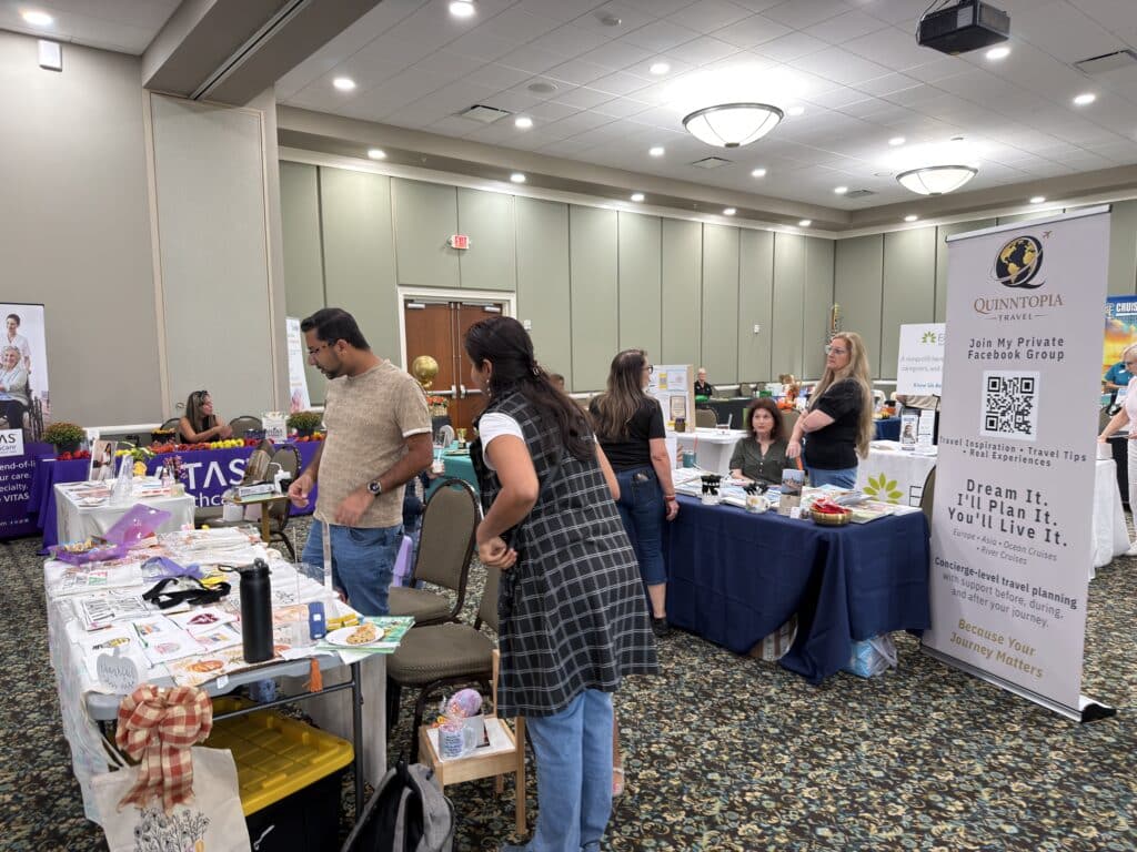 Vendor tables and banners in the event hall with guests browsing