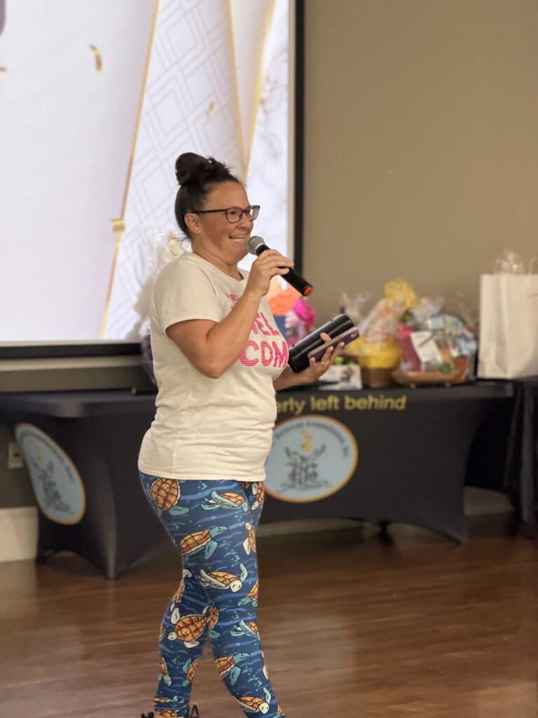 Woman in patterned leggings speaking into a microphone on stage