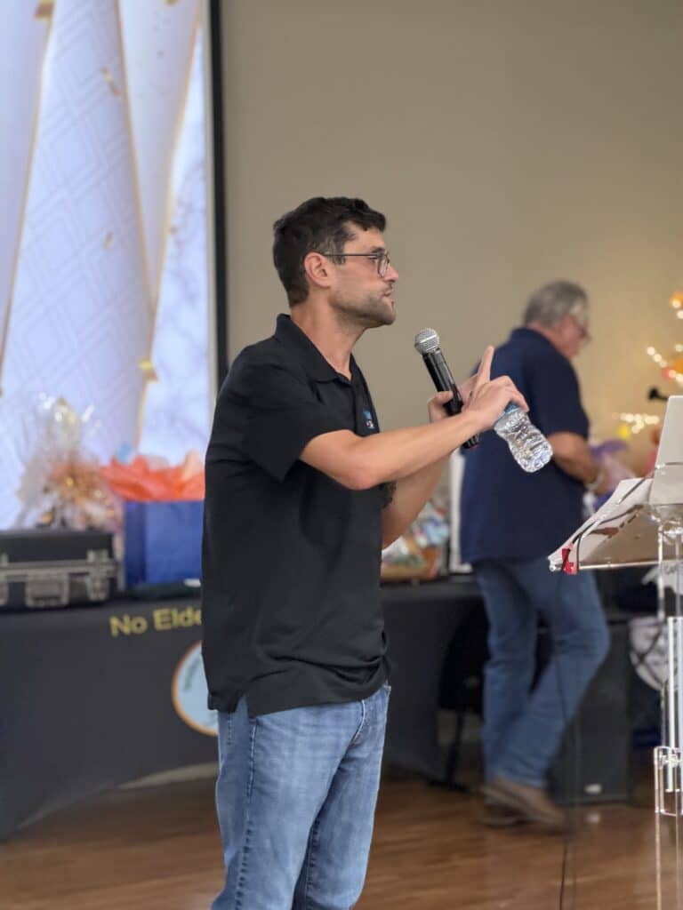 Man speaking into a microphone at the event